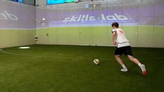 Ein junger Mann trainiert die Skills.lap Übung "Sprint-Parcour mit Ball", bei der mit dem Fußball einen Lichtpunkt auf dem Spielfeld erreichen muss.