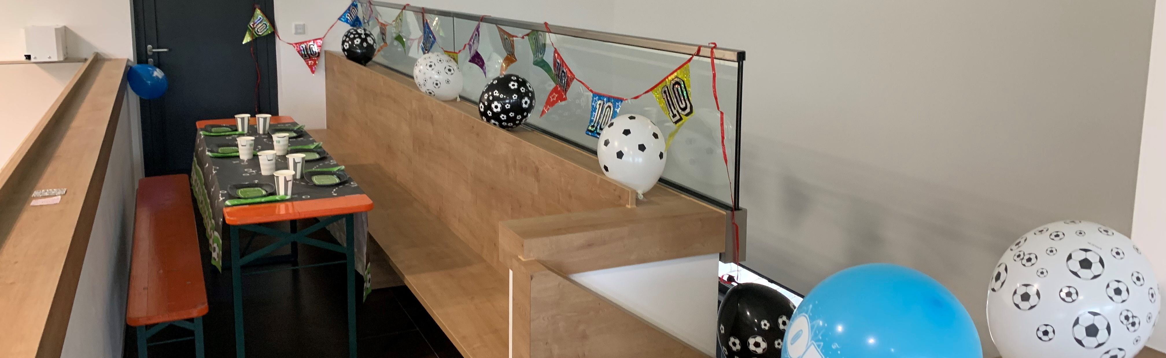 Ein mit Fußballballons und Pappgeschirr geschmückter Geburtstagstisch.